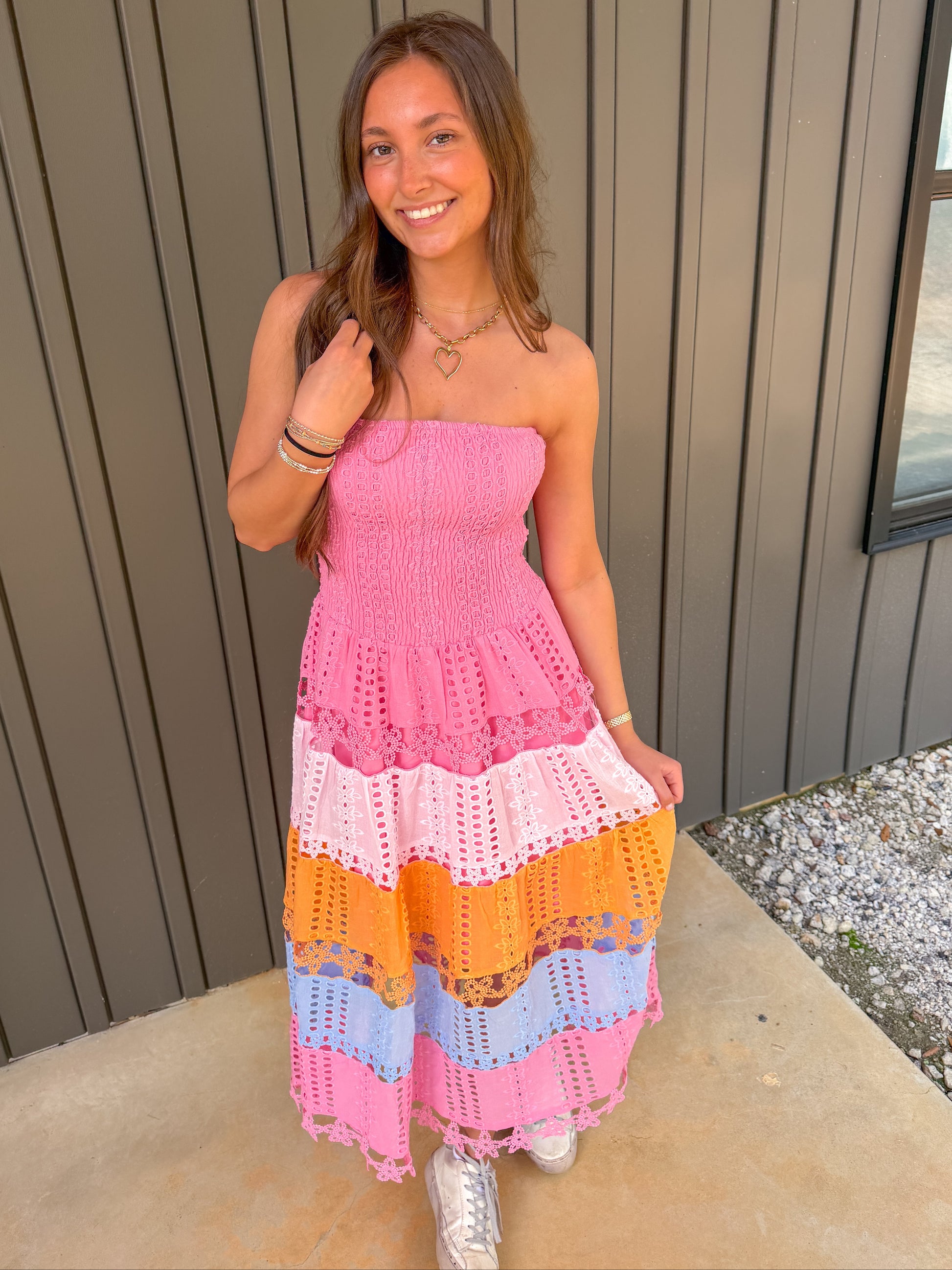 Woman wearing a colorful crochet dress standing outdoors.