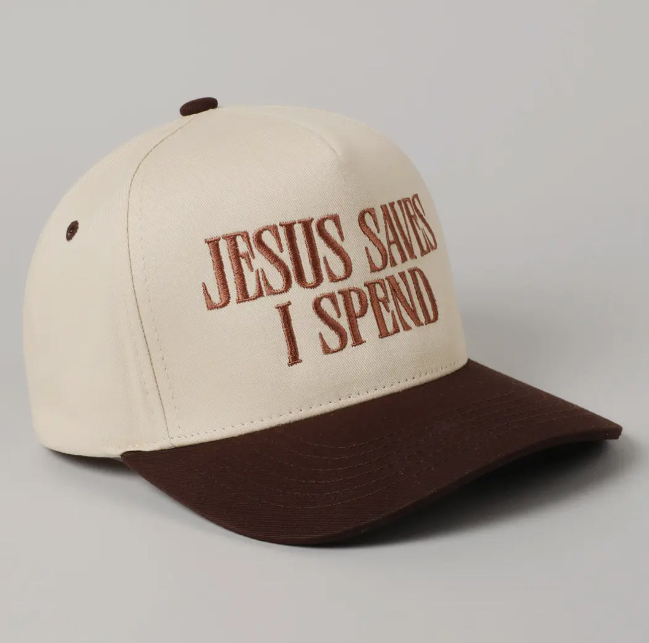Beige and brown trucker hat with embroidered text ‘Jesus Saves I Spend’ – Christian cap